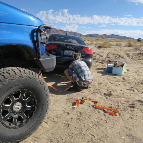 Jamison hooks up a vehicle to pull it out of the sand in the Mojave Desert.